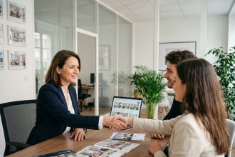 Agent immobilière signant un contrat de location avec un couple dans une agence immobilière à Montrouge